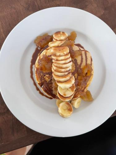 a plate of pancakes with bananas and chocolate sauce at La Posada del Buzo in Colón