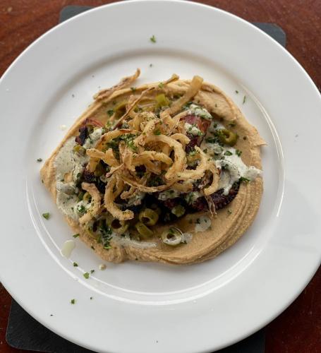 a white plate with a taco on a table at La Posada del Buzo in Colón