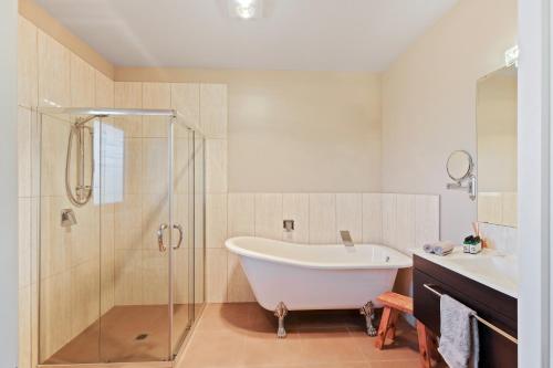 a bathroom with a tub and a shower and a sink at Hanmer High Country Views in Hanmer Springs