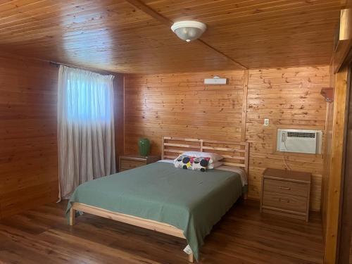 a bedroom with a bed in a wooden cabin at Cottage in Crystal Beach in Fort Erie
