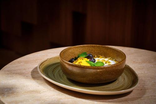 a bowl of food on a plate on a table at The Ritz-Carlton Ras Al Khaimah, Al Wadi Desert in Ras al Khaimah