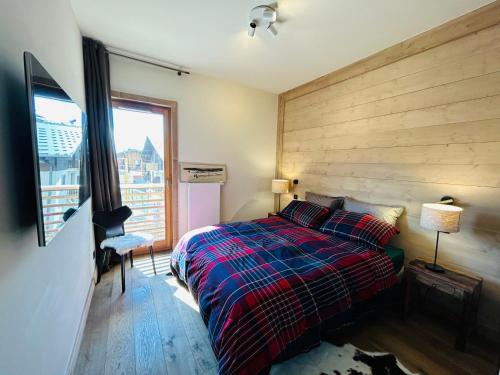 une chambre avec un lit et une grande fenêtre dans l'établissement Appartement au cœur des Gets, 2 chambres, proche pistes, parking, balcon, WiFi, ménage inclus - FR-1-623-347, aux Gets