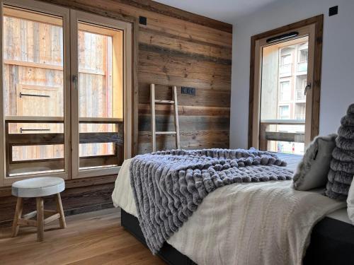 - une chambre avec un lit et un mur en bois dans l'établissement Appartement Les Gets, 3 pièces, 6 personnes - FR-1-598-154, aux Gets