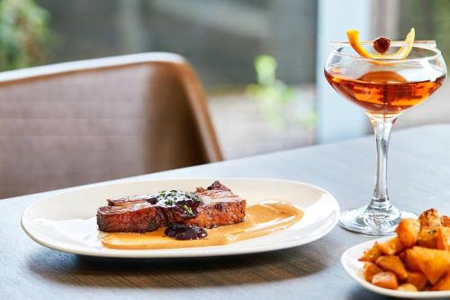 a plate of food and a drink on a table at AC Hotel Phoenix Biltmore in Phoenix