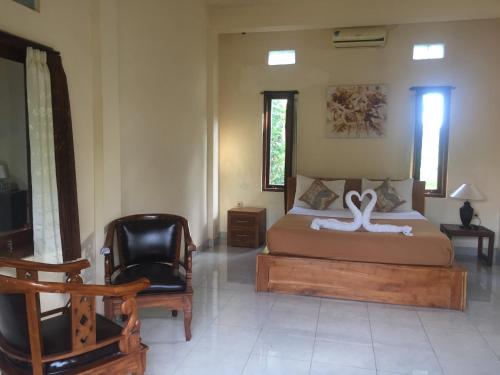 a bedroom with a bed with a white swan on it at Kenari House in Ubud