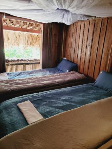 a bedroom with two beds and a window at Lagom Su Phi Retreat in Hoàng Su Phì