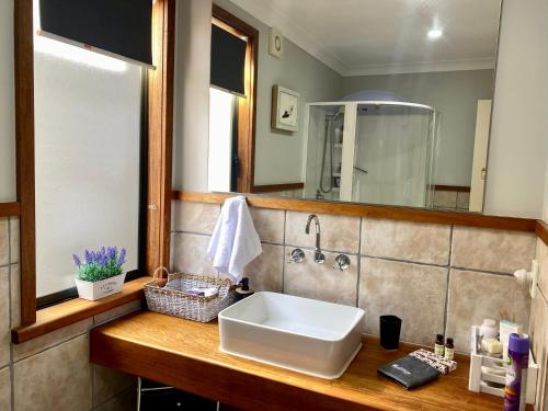 a bathroom with a sink and a mirror at The Nest - Relax & Unwind with Breathtaking Views over Lake Taupo in Taupo