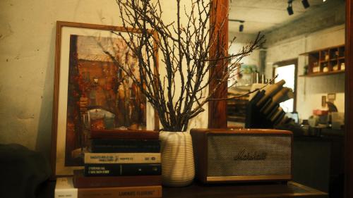 a table with a vase and a radio and a picture at Vũ House Phú Yên- Boutique Room & Breakfast in Tuy Hoa