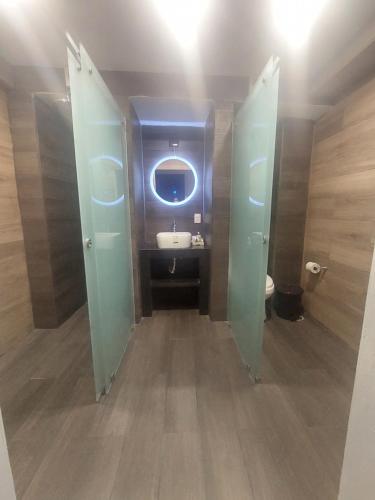 ein Bad mit einem Waschbecken und einem WC mit einem Spiegel in der Unterkunft Hotel Cantera Jaguar in San Juan Teotihuacán