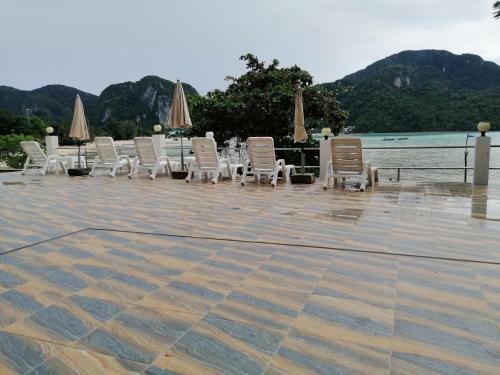 a row of chairs and tables with umbrellas on a patio at Phi Phi View Point Resort in Phi Phi Don