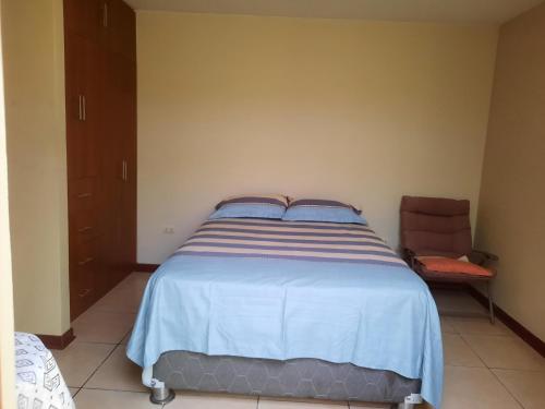 - une chambre avec un grand lit et une chaise dans l'établissement Alameda los Incas., 