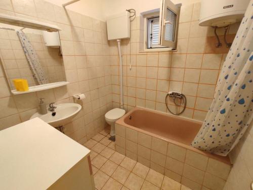 a bathroom with a tub and a toilet and a sink at Apartments Naki - free parking in Slatine