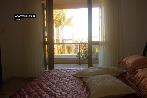 Cama frente a una ventana con vistas en Casa na Praia da Vila em Imbituba a 30 metros da praia, en Imbituba