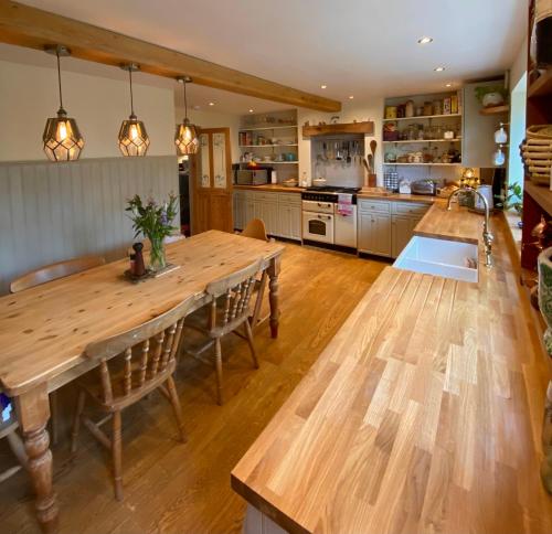 a kitchen with a large wooden table and chairs at Cottage in the Heart of Frome in Frome