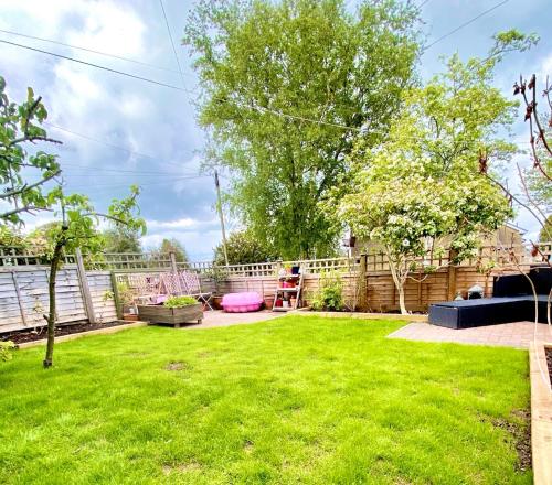 a backyard with green grass and a fence at Cottage in the Heart of Frome in Frome