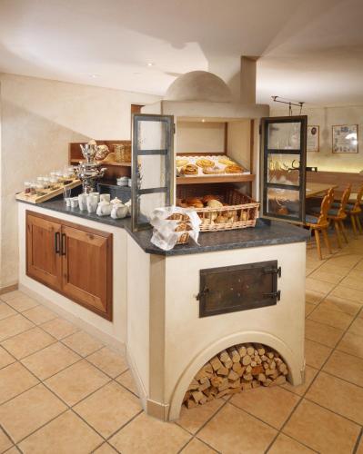 a kitchen with an oven with a bunch of pastries at Hotel Natur-Landhaus Krone in Maierhöfen