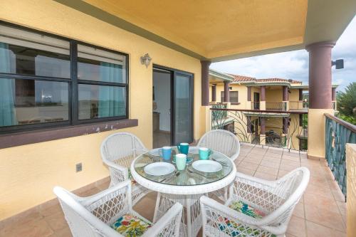 een patio met een tafel en stoelen op een balkon bij Pineapple Villa 442 condo in Roatan