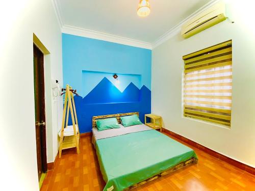 a bedroom with a bed with a blue wall at Lion Homestay in Ninh Binh