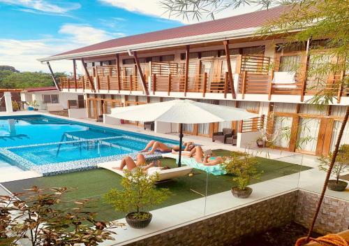 two people laying in chairs next to a swimming pool at Ananda Resort in Panglao