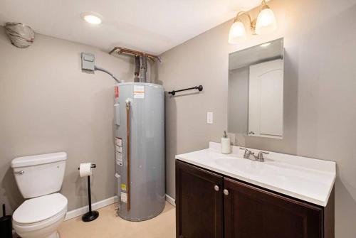 a bathroom with a toilet and a sink and a refrigerator at Game/Theater Room - Barbecue - Central Location in Omaha