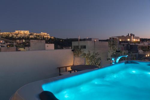 a hot tub on the roof of a building at night at Living Stone Condo Hotel in Athens