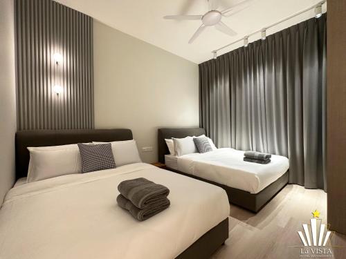 een slaapkamer met 2 bedden en een plafondventilator bij Bali Residences Melaka by Lá VISTA in Melaka