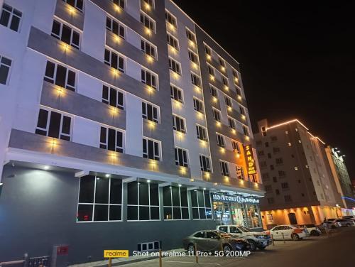 un edificio alto con coches estacionados frente a él en Hotel Sand View en Bawshar