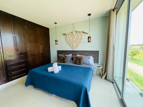 Un dormitorio con una cama azul y una ventana en Magnolia A Luxury stay 5 minutes from Downtown, en Tepatitlán de Morelos
