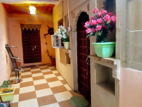 a hallway with flowers on a counter in a house at Nomadic Backpackers Hostel in Jaisalmer