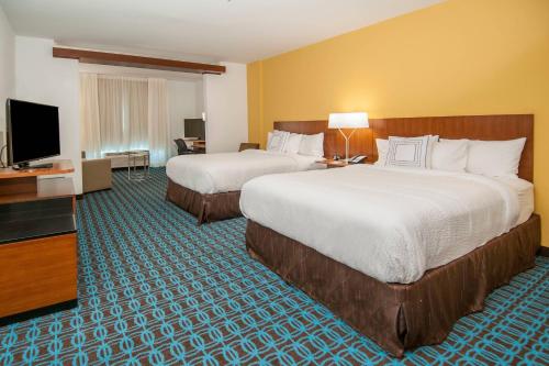 a hotel room with two beds and a flat screen tv at Fairfield Inn & Suites by Marriott LaPlace in Laplace