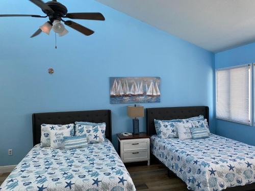 1 dormitorio con 2 camas y ventilador de techo en Legend oaks, en Gautier