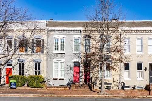 a large white building with red doors on a street at Astonishing Old Town Colonial Home with parking CozySuites in Alexandria