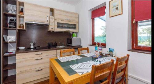 cocina con mesa y sillas y cocina con encimera en Holiday home in Balatonkeresztur 43400, en Balatonkeresztúr