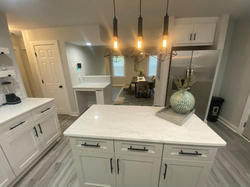 a kitchen with white cabinets and a vase on a counter at East Point Atlanta - Spacious 5BR Retreat! in Atlanta