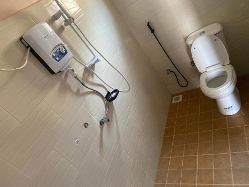 a bathroom with a toilet and a hair dryer on the wall at Zoe heights villas in Kalungu