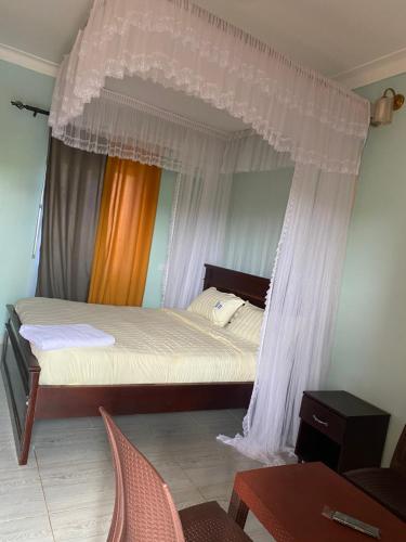 a bedroom with a bed with a canopy at Zoe heights villas in Kalungu