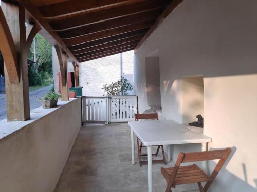 d'une table blanche et de deux chaises sur un balcon. dans l'établissement Maison 4 personnes, à Caillac