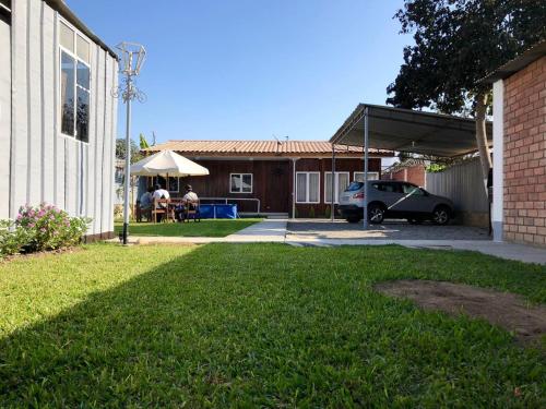 a house with a car parked in a yard at Exclusiva Casa de madera Lunahuana in Lunahuaná