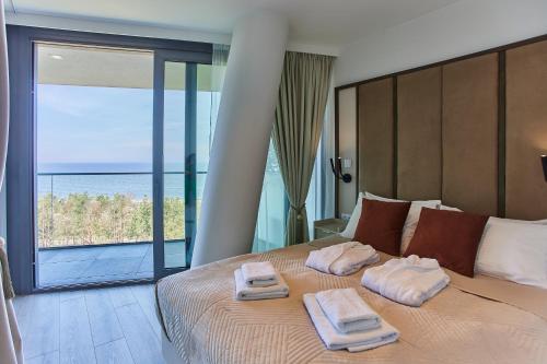 a bedroom with a large bed with towels on it at Wave - Endless Sea View Apartment in Międzyzdroje