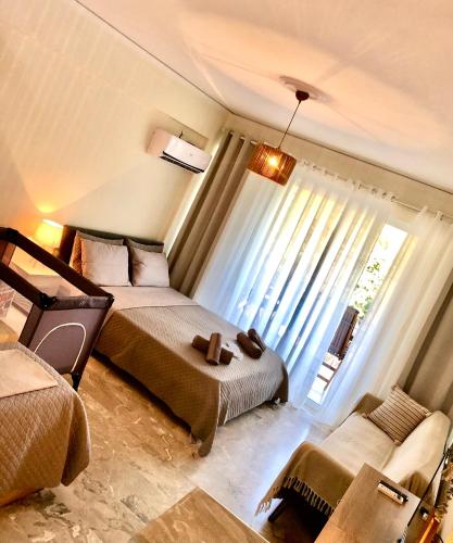 a bedroom with two beds and a window at Studio στο Τολό in Tolo