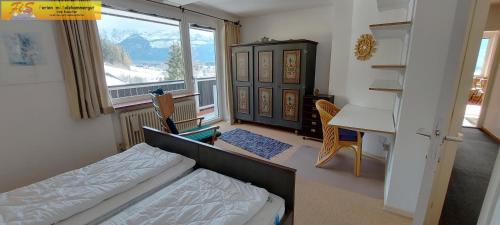 1 dormitorio con cama, escritorio y ventana en Wohnung Katalin by FiS - Fun in Styria, en Bad Mitterndorf