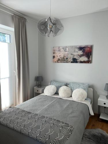 a bedroom with a bed and a chandelier at V71A Kauno Centre in Kaunas