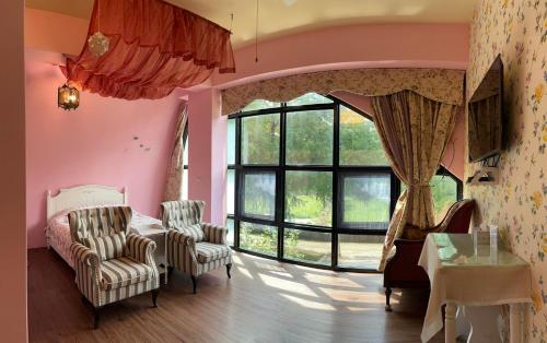 een woonkamer met roze muren en een groot raam bij Maison-Philo Homestay B & B in Sanyi