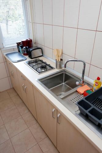 a kitchen counter with a sink and a stove at My Cozy Place in Bucharest