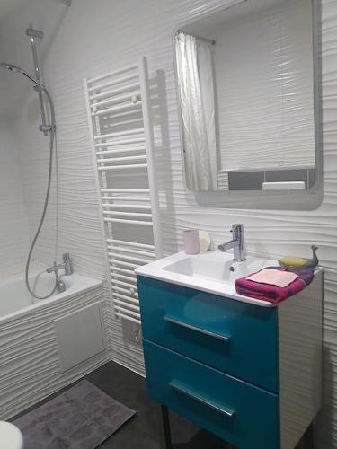 une salle de bain avec un lavabo bleu et un miroir dans l'établissement Un cocon au cœur de Bordeaux., à Bordeaux