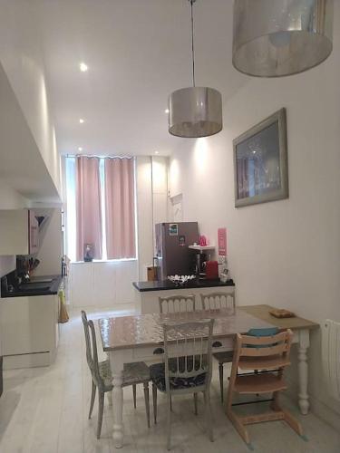 - une cuisine avec une table à manger et des chaises dans l'établissement Un cocon au cœur de Bordeaux., à Bordeaux