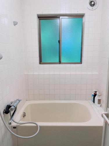 a white bath tub with a window in a bathroom at Cate no mori - Vacation STAY 52818v in Shime