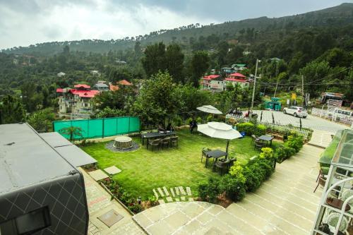 an aerial view of a garden with tables and umbrellas at Kaffberry Cafe & Homestays in Kūd