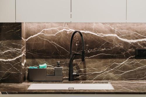 - un évier de cuisine avec un comptoir en marbre noir dans l'établissement Bed & Breakfast dei sogni, à Ascoli Piceno