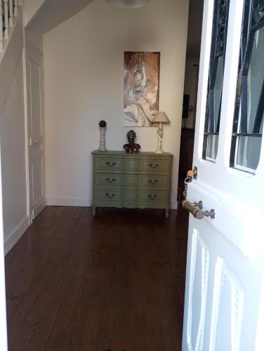 un couloir avec une commode et un tableau sur le mur dans l'établissement Jolie maison quartier Vesone, à Périgueux